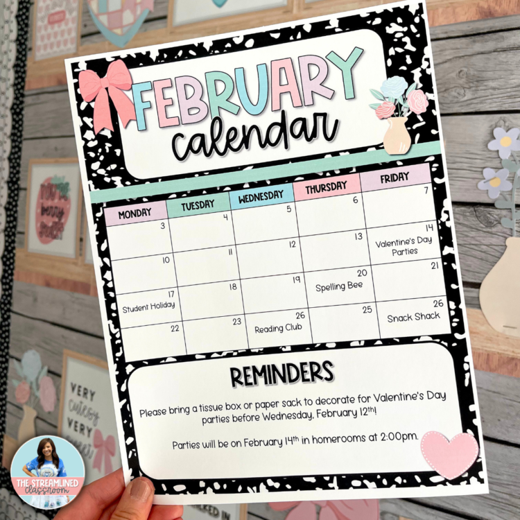 A photo of a printed February classroom calendar being held up. The calendar features a pink and blue header, a clean grid layout, and a reminders section at the bottom. The design follows the composition notebook theme with cute hearts and a bow, adding a festive Valentine’s touch.