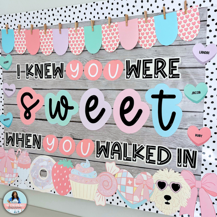 A real-life classroom setup of the Swiftie-inspired Valentine’s bulletin board, featuring pastel candy hearts with student names, decorative banners, and themed clipart arranged on a wooden backdrop. The phrase "I Knew You Were Sweet When You Walked In" is prominently displayed in a mix of fun fonts and colors.