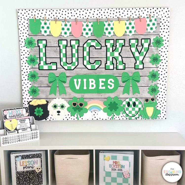 Fully assembled Lucky Vibes bulletin board with green checkerboard letters, editable student name clovers, and spring-themed accent pieces, including rainbows, frogs, and bows, displayed above a classroom storage shelf.