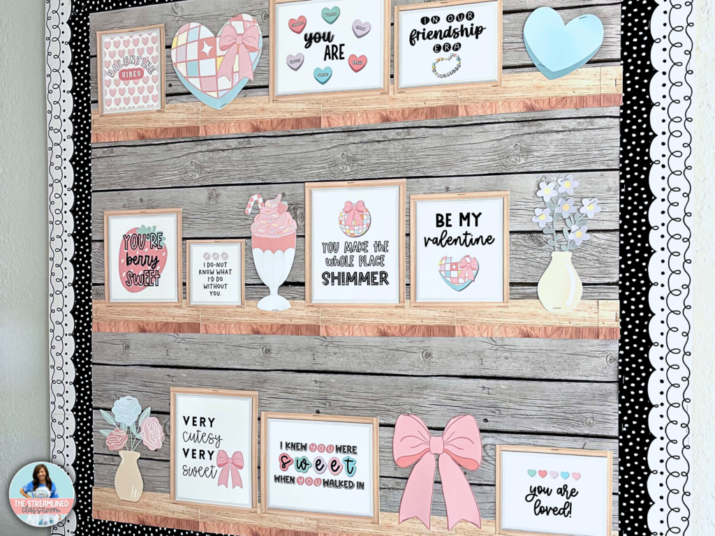 A real classroom bulletin board featuring framed Valentine’s quotes, pastel bows, and candy hearts arranged on wood-look printable shelves. The display has a black-and-white polka dot border for a stylish finish.