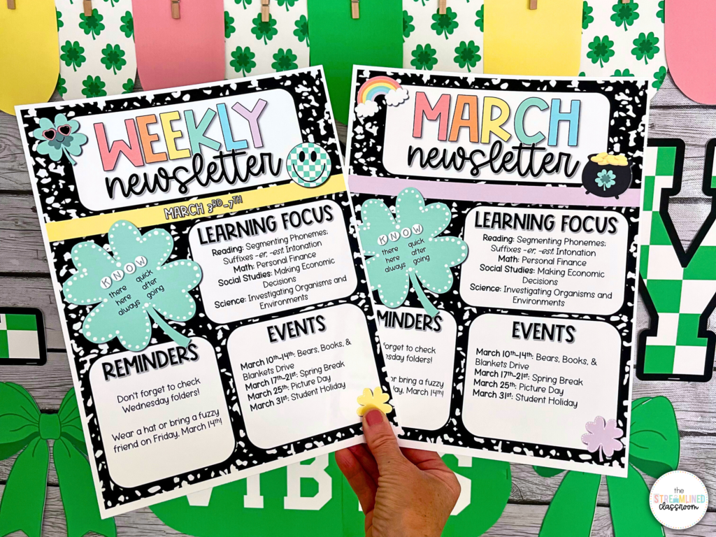 Hand holding both the weekly and March newsletter templates in front of a St. Patrick’s Day-themed classroom bulletin board.