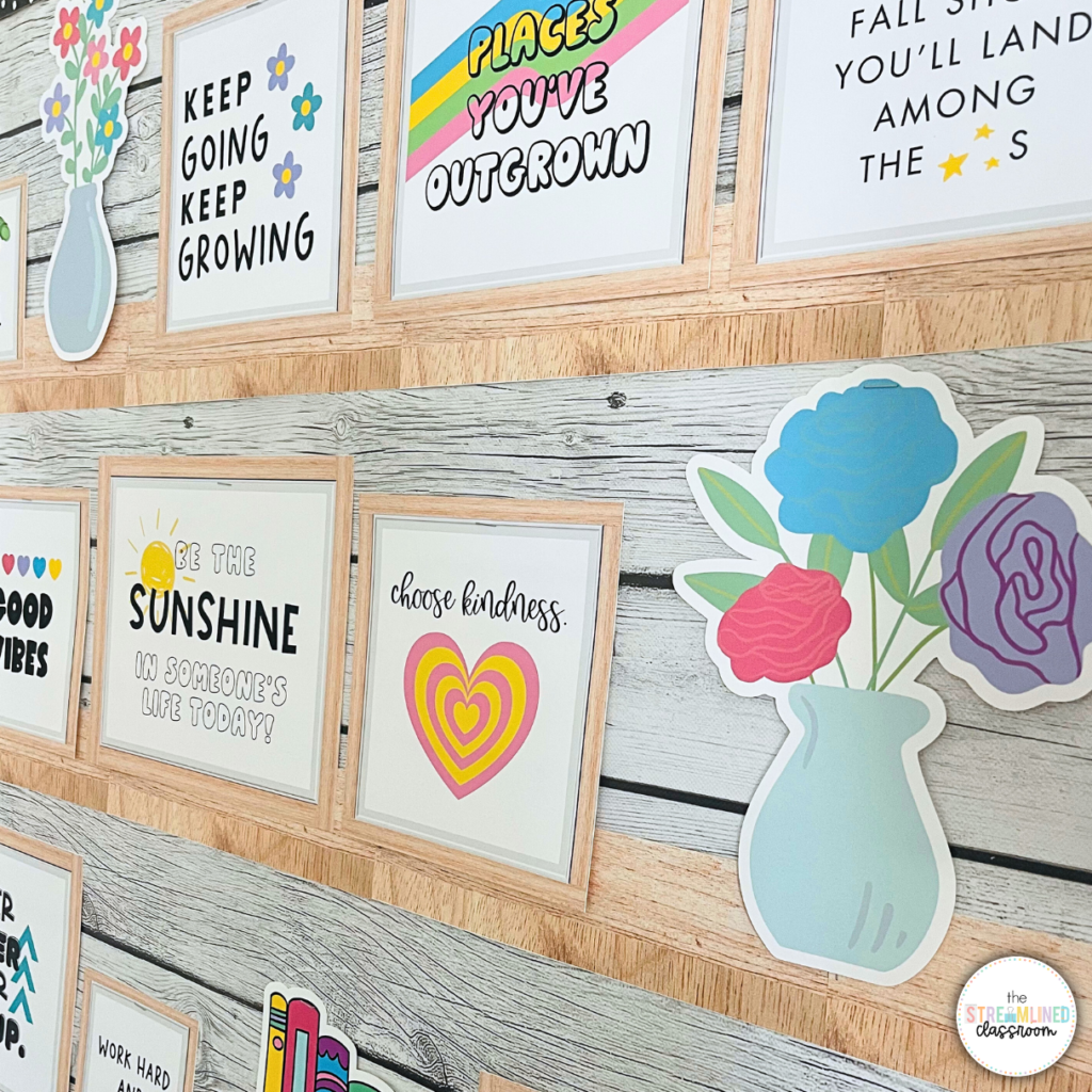 A classroom wall decorated with framed inspirational quotes, including "Keep going, keep growing," "Be the sunshine in someone's life today," and "Choose kindness." The frames have a light wood appearance, complementing a wood-textured background. Cutouts of vases with colorful flowers and other decorative elements add a cheerful, retro touch.