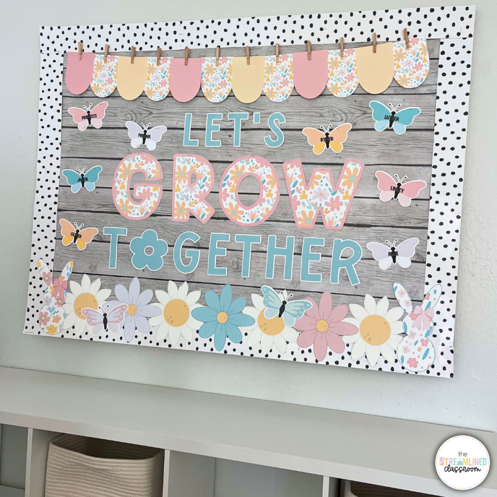 A classroom door or bulletin board with the phrase "Let's Grow Together" in a mix of pastel and floral-patterned letters. The background has a wood-style design with polka dot accents. The display is decorated with butterflies, flowers, and a scalloped paper banner in coordinating pastel tones.