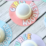 Pastel classroom push light hall passes labeled Boys' Restroom, Girls' Restroom, Nurse, Office, and Other, displayed on wooden background.